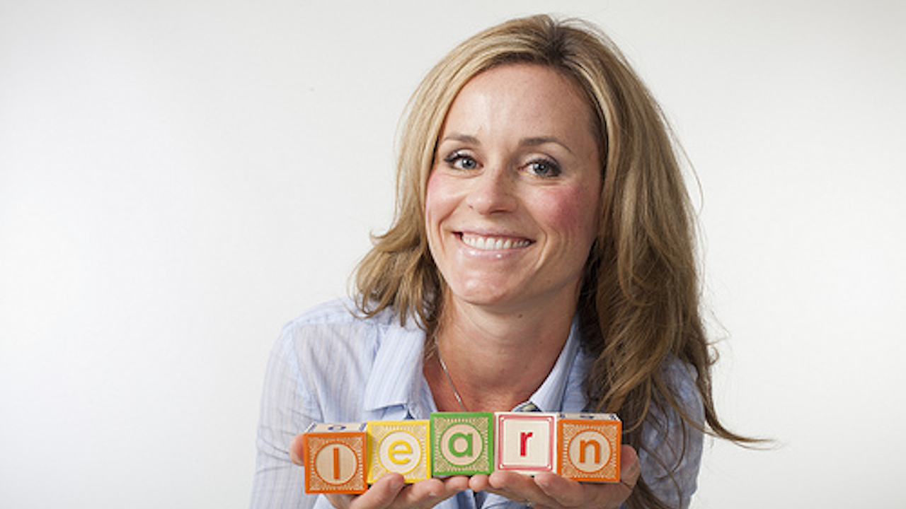 Catlin holding letter blocks that spell L E A R N