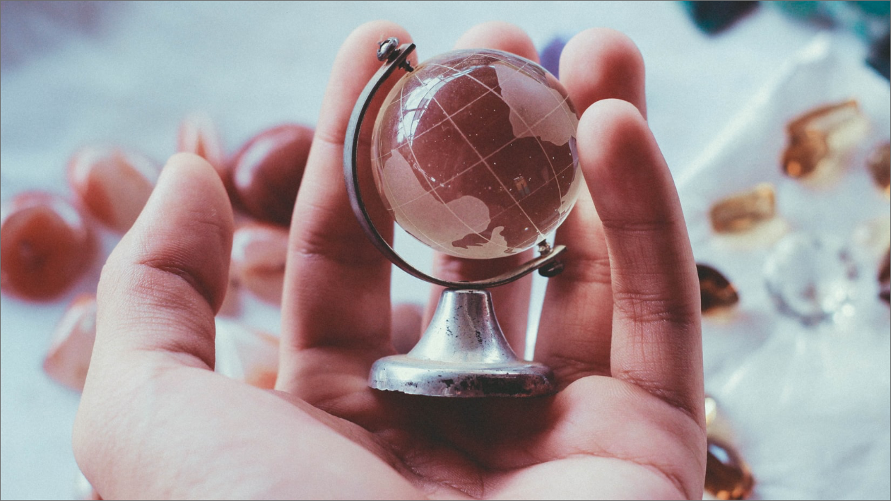 hand holding a small globe