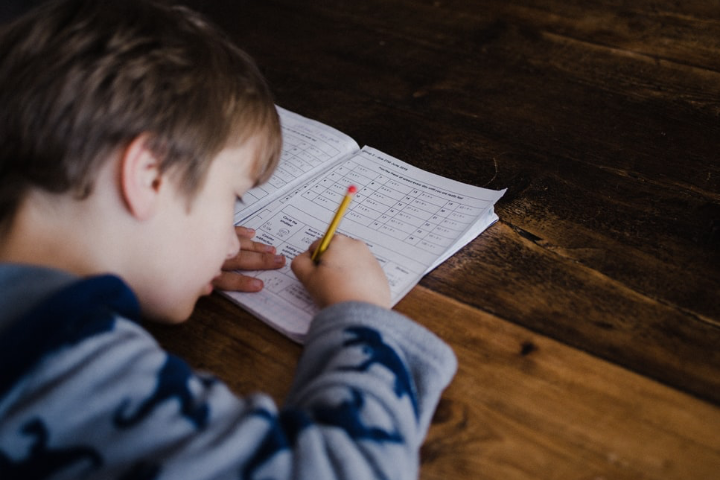 Kid answering Math workbook